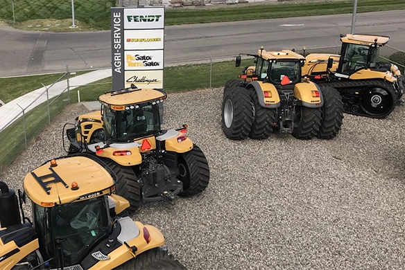 Challenger tractors on display at an Agri-Service dealership lot with branded signage