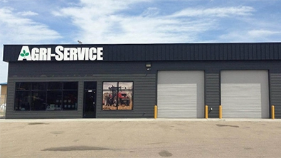Exterior of Agri-Service Marsing dealership with signage and service bays.
