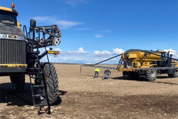 Agri-Service technicians and customers working together on TerraGator equipment setup in a wide open field