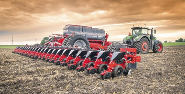 Fendt tractor pulling a HORSCH planter across a freshly tilled field under a dramatic orange sky, showcasing advanced planting equipment in action.