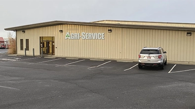 Agri-Service Moses Lake dealership exterior with parking lot and entrance view.