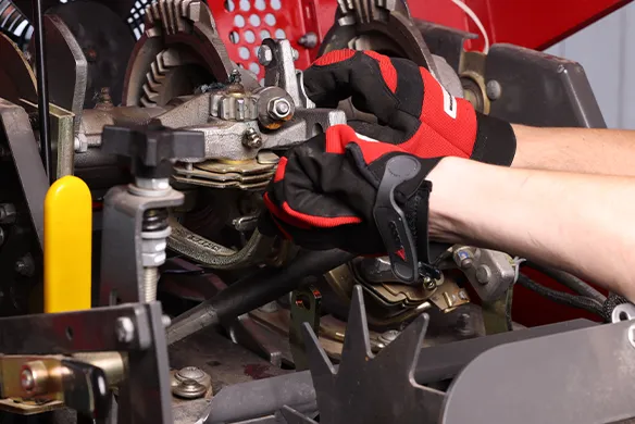 Service technician working on a baler knotter system.
