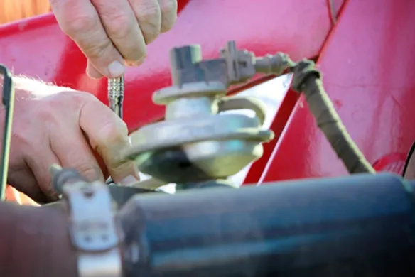 Close up of an Agri-Service technician working on a piece of farm equipment.
